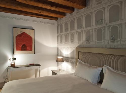 a bedroom with a white bed and a wall with birds at La Barchessa di Villa Pisani in Lonigo