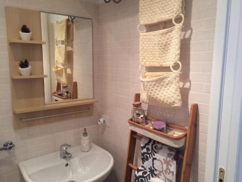 een badkamer met een wastafel, een toilet en een spiegel bij Il Rifugio di Mattia in Polignano a Mare