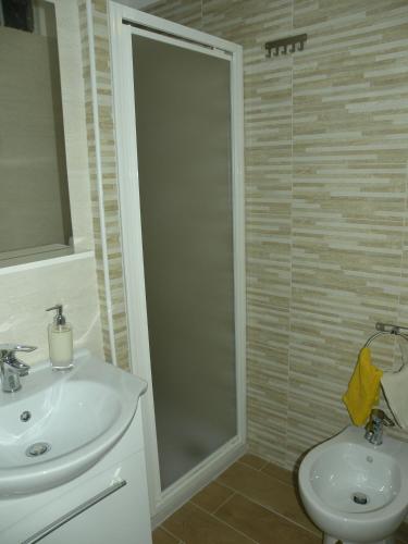 a bathroom with a sink and a toilet and a shower at Al Blu Ortigia Apartments in Syracuse