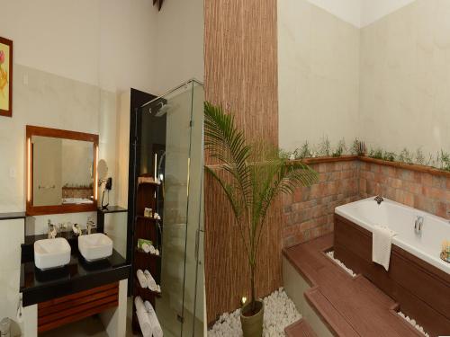 a bathroom with two sinks and a shower and a tub at Siddhalepa Ayurveda Resort - All Meals, Ayurveda Treatment and Yoga in Wadduwa