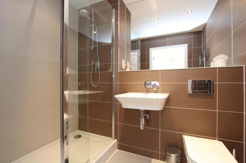 y baño con lavabo y ducha. en Luxury Apartments With Secure Parking en Reading