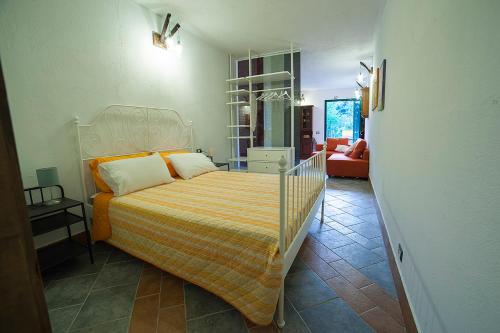 ネーにあるCà di Gatti Apartmentのベッドルーム1室(オレンジと黄色の毛布を使用したベッド1台付)