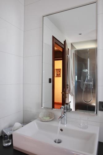 a bathroom with a sink and a large mirror at Hotel Restaurant L'Ami Fritz in Ottrott
