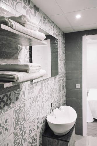 a bathroom with a sink and a mirror at Deluxe Hostels & Suites Merida in Merida