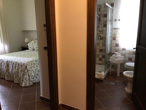 a bedroom with a bed and a bathroom with a toilet at Il Casale di Riardo Luxury B&B in Riardo