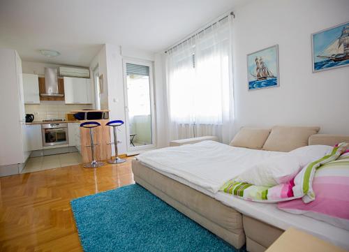 1 dormitorio con 1 cama grande y cocina en Apartment Luka, en Zagreb