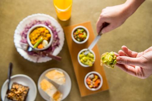 a person is eating food on a table at Pousada Paiol in Atibaia