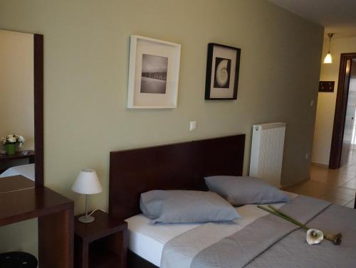 a bedroom with a bed with two blue pillows at Ameris Studios & Apartments in Neos Marmaras
