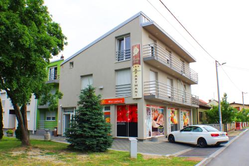 a white car parked in front of a building at Bokun Apartments III in Sisak