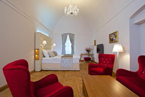 una camera con un letto e due sedie rosse di Zámek Ratměřice - Hotel & Resort a Ratměřice