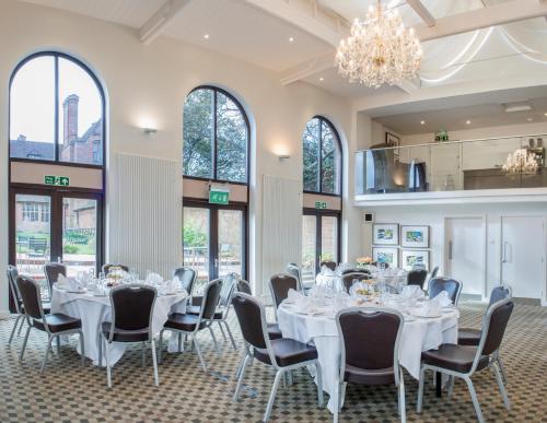a conference room with white tables and chairs and windows at New Place in Fareham