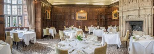 a dining room with white tables and chairs and a fireplace at New Place in Fareham