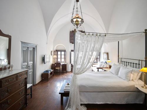 a bedroom with a white bed with a canopy at 1864 The Sea Captain's House in Oia