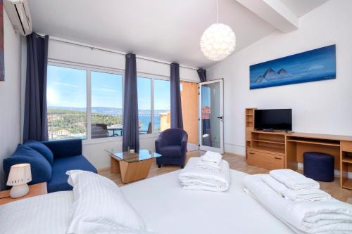 1 dormitorio con 1 cama y TV y algunas ventanas en Big Blue, en Jelsa