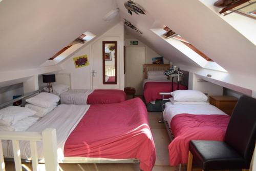 a bedroom with three beds with red sheets at Clifton Bridge Hotel in York