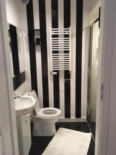 a black and white bathroom with a toilet and a sink at Morski Relax in Gdynia