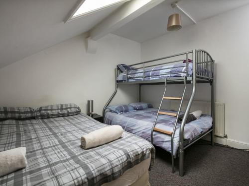 Un dormitorio con dos literas y una escalera. en Chorlton Townhouse, en Mánchester