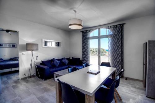 ein Wohnzimmer mit einem blauen Sofa und einem Tisch in der Unterkunft Appartement avec splendide vue mer, à 200 m de la plage, Golfe de Saint-Tropez in Les Issambres