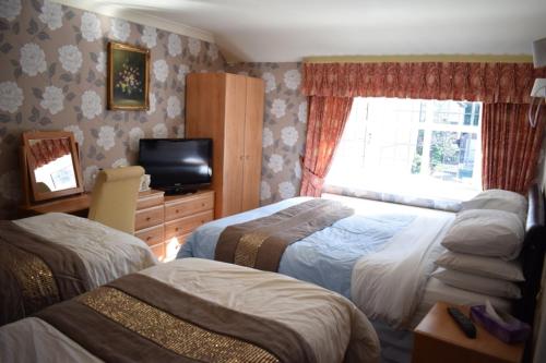 a hotel room with two beds and a television at Clifton Bridge Hotel in York
