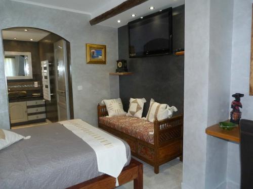 1 dormitorio con 1 cama y TV en la pared en Les Bambous B&B en Levens