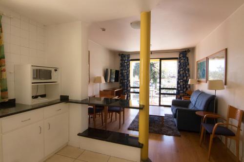 una cucina e un soggiorno con tavolo e sedie di Apartamentos Turisticos Avenue Park a Funchal