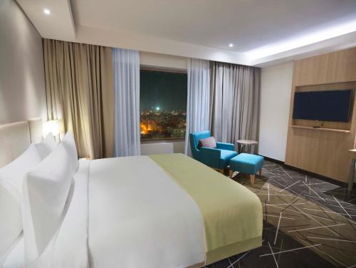 a hotel room with a large bed and a large window at Holiday Inn Chennai OMR IT Expressway by IHG in Chennai