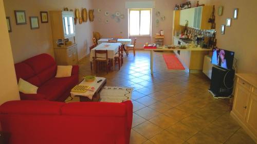 a living room with a red couch and a kitchen at Antas in Padria