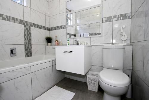 Un baño blanco con inodoro y bañera. en 6 Ipanema Beach, en Durban