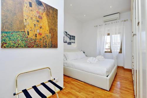 ローマにあるCozy Leone - My Extra Homeのベッドルーム1室(ベッド1台付)が備わります。壁には絵画が飾られています。