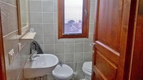 ein Bad mit einem Waschbecken, einem WC und einem Fenster in der Unterkunft B&B Stella Maris in Magomadas