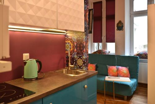 クラクフにあるLa Gioia Magic Orient Apartmentsのキッチン(シンク、青いソファ付)