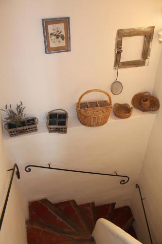 un escalier avec des paniers sur un mur dans l'établissement Duplex en plein centre, à LʼIsle-sur-la-Sorgue