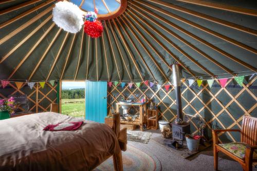 a bedroom in a yurt with a bed and a fireplace at Swinton Bivouac in Masham