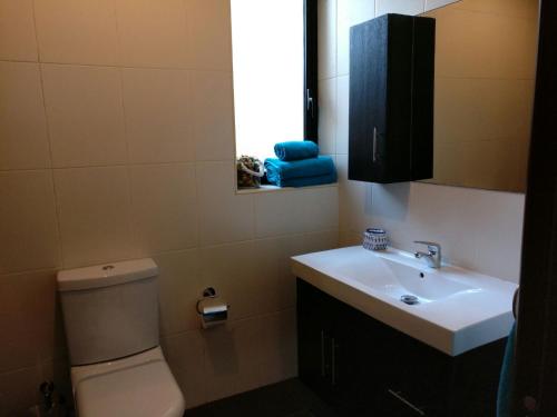 łazienka z toaletą, umywalką i oknem w obiekcie Mandalay w mieście Mellieħa
