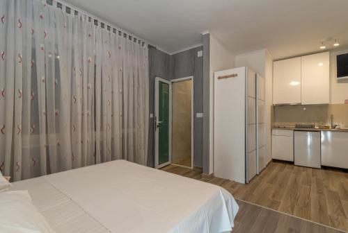 een slaapkamer met een wit bed en een keuken bij Villa Marija in Trogir