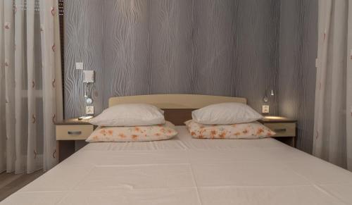 a bedroom with a bed with two pillows on it at Villa Marija in Trogir
