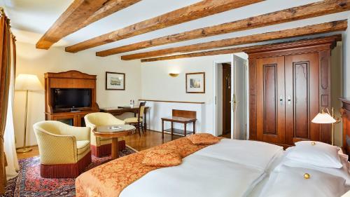 a bedroom with a bed and a living room at Radisson Blu Hotel Altstadt in Salzburg