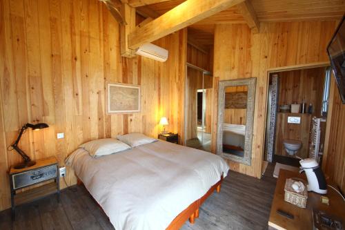 une chambre avec un grand lit dans une pièce en bois dans l'établissement Villa Lodge Natureo, à Seignosse