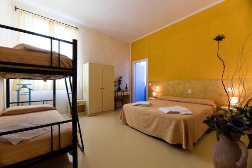 una camera con 2 letti a castello e una parete gialla di Hotel Il Ponte a Cecina