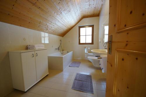 La salle de bains est pourvue d'un lavabo, d'une baignoire et de toilettes. dans l'établissement Soroea, à San Vigilio Di Marebbe