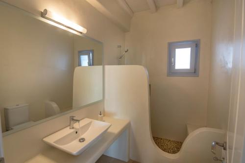 a white bathroom with a sink and a mirror at Passos Villas in Parasporos
