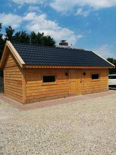 a large wooden building with a black roof at Hotel Bieze in Borger