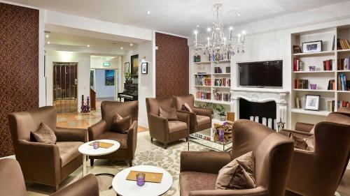 a living room with chairs and a fireplace at Radisson Blu Hotel Altstadt in Salzburg