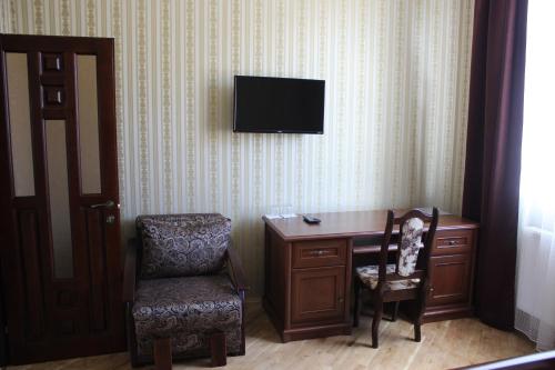 a living room with a tv and a chair at Complex Zolota Pidkova in Zolochiv