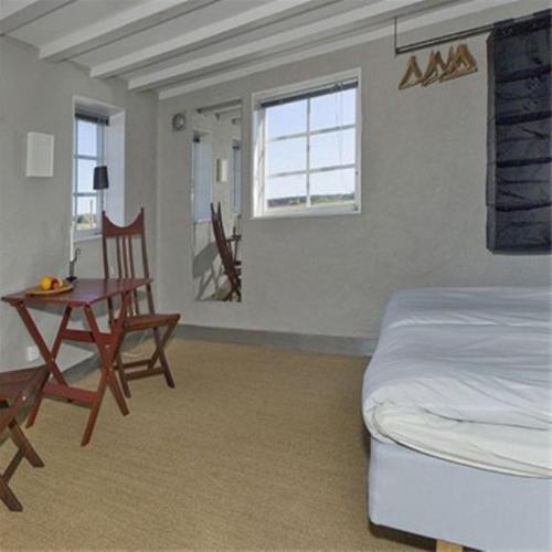 a bedroom with a bed and a table and chairs at Gotland Magazin1 Guesthouse in Havdhem
