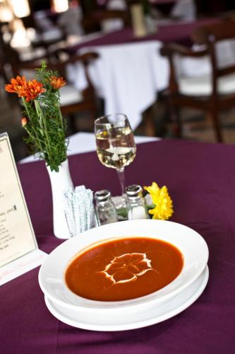 a bowl of soup on a purple table with a glass of wine at Tamukami Hotel in Sanur