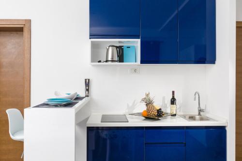 a kitchen with blue cabinets and a sink at Apartments 26 in Kotor