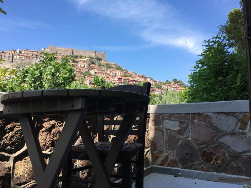 a wooden chair sitting next to a table with a view of a mountain at Olive Press Hotel in Mithymna