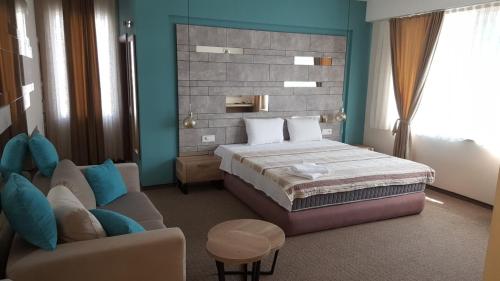a bedroom with a bed and a couch at Hotel Emka in Tetovo