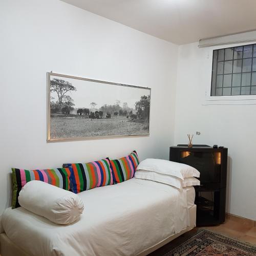 a white room with a couch and a picture on the wall at L'albero Del Pepe in Fiano Romano